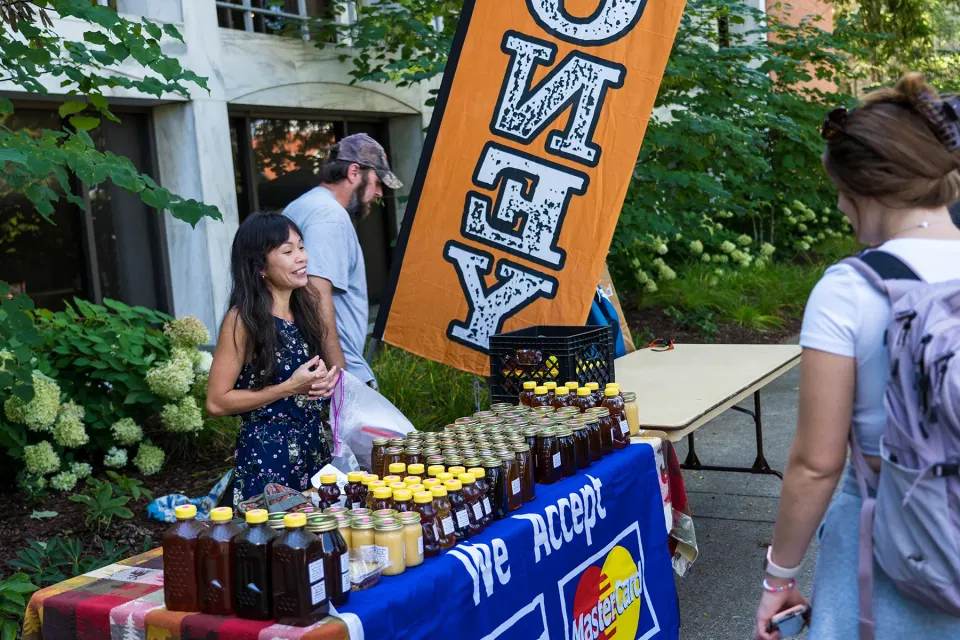 A student browsing a vendor's stand at the WVU Farmer's Market.